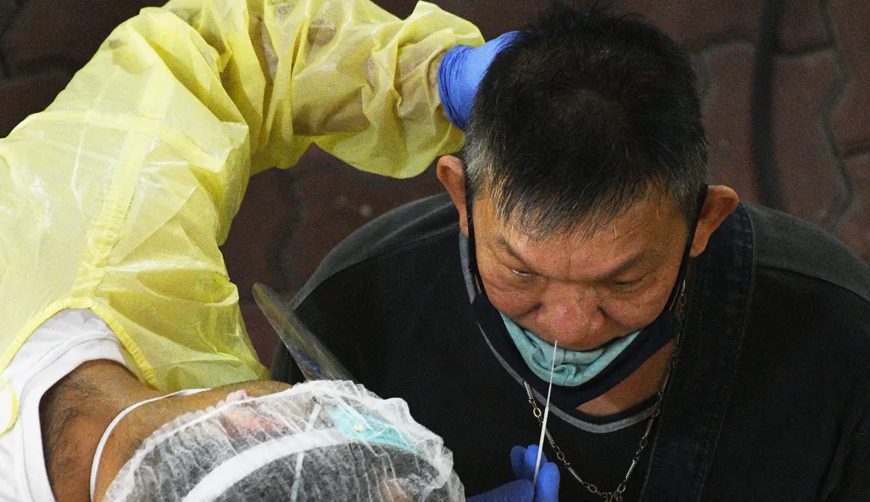 Seorang petugas kesehatan mengumpulkan sampel usap (swab) untuk pengujian COVID-19 dari para pekerja yang siap kembali bekerja di pusat penapisan (screening) regional di Singapura (10/6/2020). (Xinhua/Then Chih Wey)