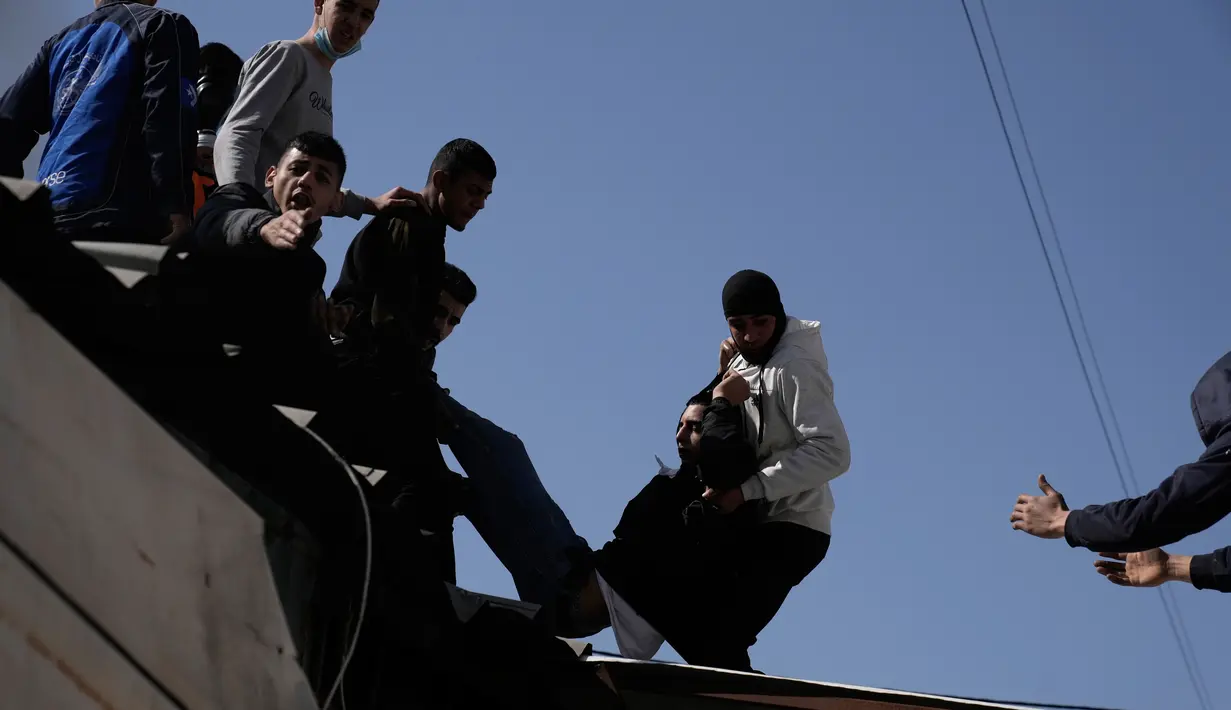 Seorang warga Palestina yang terluka dipindahkan selama bentrokan dengan pasukan Israel di Kota Nablus, Tepi Barat, 22 Februari 2023. Para saksi menggambarkan tentara Israel melepaskan tembakan tanpa pandang bulu. (AP Photo/Majdi Mohammed)
