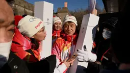 Aktor Jackie Chan dan seorang pembawa obor terlihat di Tembok Besar Badaling pada hari kedua estafet obor di Beijing pada 3 Februari 2022, sehari sebelum dimulainya Olimpiade Musim Dingin Beijing 2022. (AFP/Noel Celis)