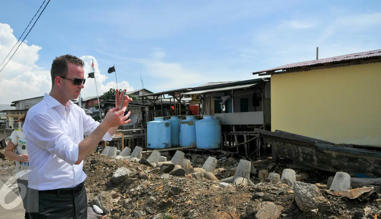 Staf Menteri Lingkungan dan Pangan Denmark, Esben Lunde Larsen memfoto keadaan Muara Angke, Jakarta, Senin (11/4/2016). Kedatangan Esben untuk melihat kondisi sampah di pinggiran Pantai Muara Angke. (Liputan6.com/Yoppy Renato)