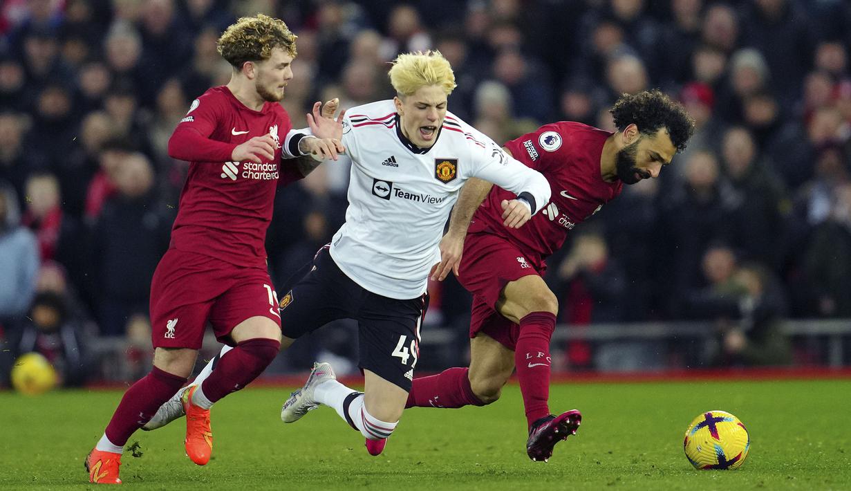 Pemain Liverpool, Mohamed Salah (kanan) dan Harvey Eliott berusaha merebut bola dari pemain Manchester United, Alejandro Garnacho (tengah) pada laga pekan ke-26 Liga Inggris 2022/2023 yang berlangsung di Anfield, Liverpool, Senin (06/03/2023) WIB. (AP Photo/Jon Super)