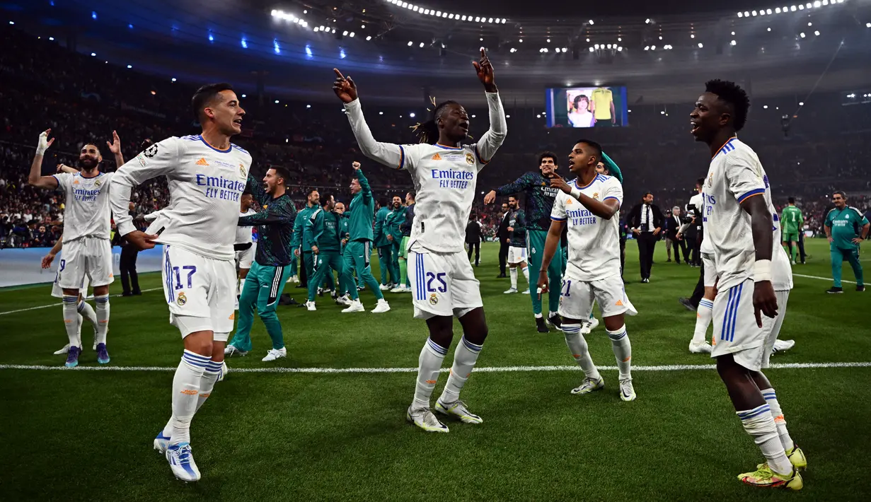 Pemain Real Madrid Lucas Vazquez (kiri), Angola Eduardo Camavinga (kedua dari kiri), Vinicius Junior (kanan), dan Rodrygo Goes (kedua dari kanan) merayakan kemenangan mereka pada pertandingan final Liga Champions usai mengalahkan Liverpool di Stade de France, Saint-Denis, Prancis, 28 Mei 2022. Real Madrid mengalahkan Liverpool 1-0. (Anne-Christine POUJOULAT/AFP)