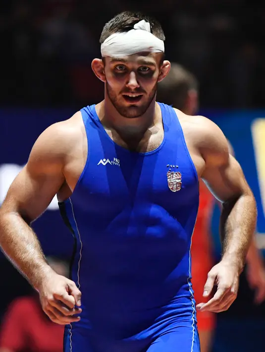 Pegulat Rusia, Aleksandr Chekhirkin dengan kepala yang dibalut perban tetap melanjutkan pertandingan pada Kejuaraan Gulat Dunia di Paris, Prancis, Senin (21/8). Aleksandr mengalami cedera saat melawan pegulat Serbia Victor Nemes. (BERTRAND GUAY/AFP)