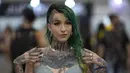 Seorang wanita berpose memamerkan tato pada tubuhnya dalam acara Sao Paulo Tattoo Week, Brasil, Jumat (25/10/2019). (AP Photo/Andre Penner)