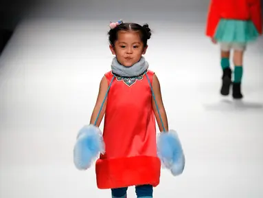 Seorang anak berjalan di atas catwalk memperagakan karya desainer Amelie Wang pada China Fashion Week di Beijing,  31 Oktober 2017. (AP Photo/Andy Wong)
