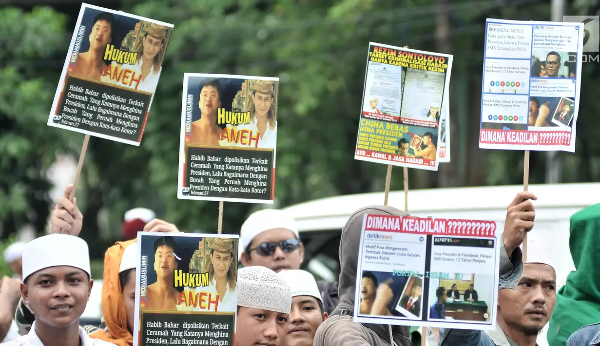 Massa Laskar Pembela Islam (LPI) saat mengawal pemeriksaan Habib Bahar bin Smith di depan Gedung Bareskrim Polri, Jakarta, Kamis (6/12). Massa membawa sejumlah poster tuntutan saat aksi. (Merdeka.com/Iqbal Nugroho)