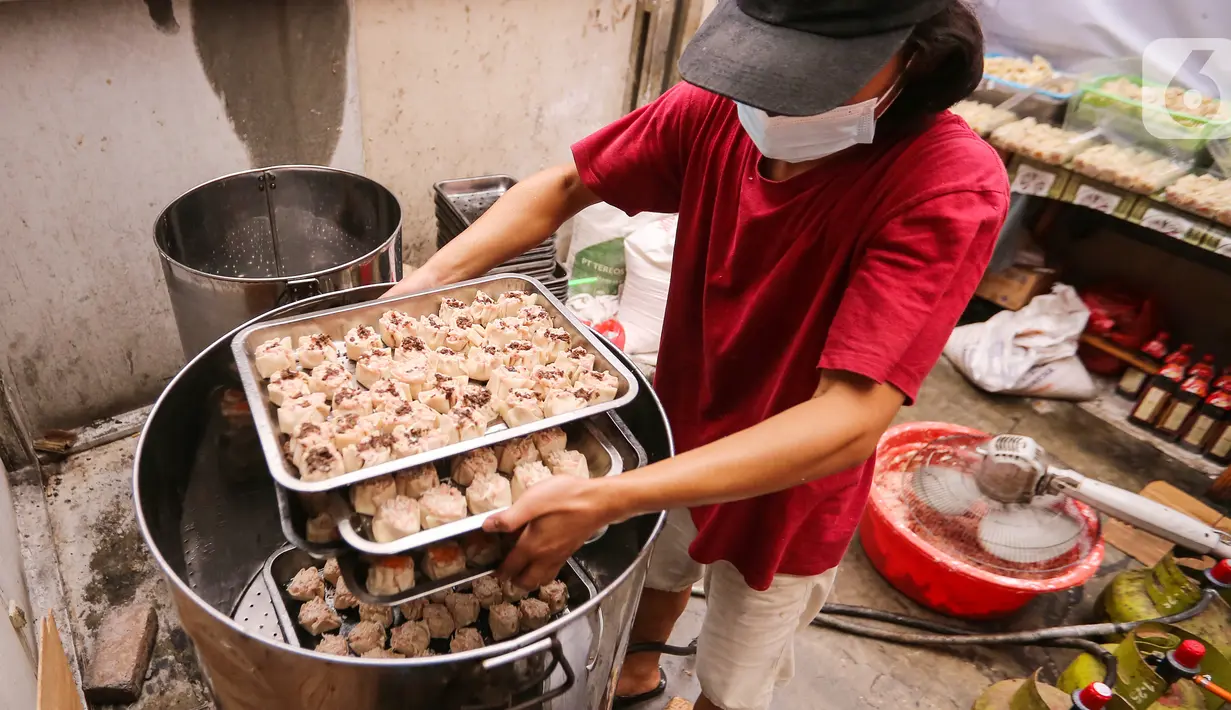 Karyawan menaruh dimsum ke dalam kukusan di Griya Dimsum Bunda Imoet, Serua, Tangerang Selatan, Rabu (9/2/2022). Dibutuhkan 5 kuintal adonan daging ayam per hari untuk membuat dimsum guna memenuhi pasar kuliner dari Jabodetabek, Lampung hingga Jawa Tengah. (Liputan6.com/Fery Pradolo)