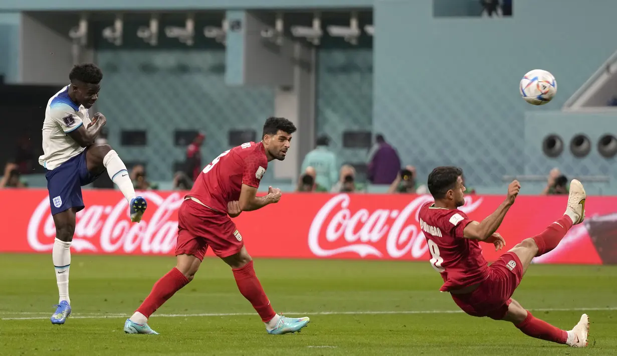 Timnas Inggris kembali menjauh untuk unggul 2-0 pada menit ke-43. Saat terjadi kemelut di depan gawang Iran, Bukayo saka sukses melepaskan tendangan kaki kiri yang bersarang di sudut kiri gawang tanpa mampu diantisipasi Hossein Hosseini. (AP/Frank Augstein)