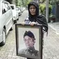 Seorang wanita memegang foto aktor senior Deddy Sutomo di dekat rumah duka kawasan Rempoa, Tangerang Selatan, Rabu (18/4). Selain berakting, Deddy Sutomo sempat menjadi anggota legislatif DPR RI komisi X periode 2004-2009. (Liputan6.com/Faizal Fanani)