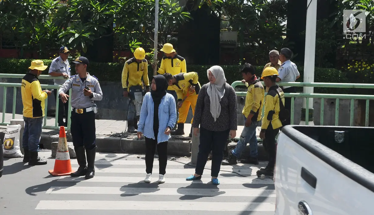 Pejalan kaki menyeberang di zebra cross kawasan Pinang Ranti, Jakarta, Senin (11/2). Zebra cross yang berada di samping Tamini Square itu sempat jadi perbincangan lantaran terhalang oleh pagar besi hijau setinggi 1 meter. (Liputan6.com/Herman Zakharia)