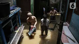 Warga bersih-bersih perabotan usai terendam banjir di kawasan Kampung Melayu, Jakarta, Senin (8/11/2021). Warga belum mengungsi dan masih berharap air akan surut. (Liputan6.com/Faizal Fanani)