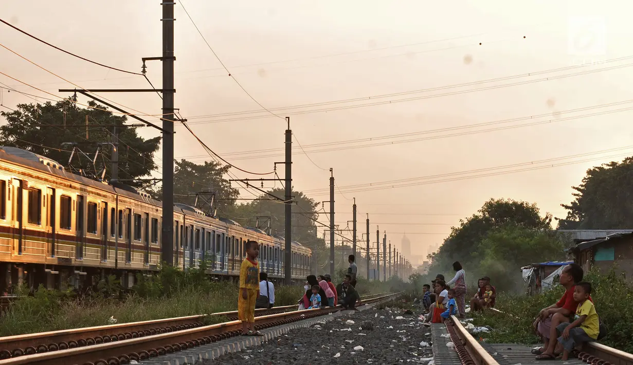 Sejumlah anak-anak didampingi orang tuanya bermain saat menunggu waktu berbuka puasa atau ngabuburit di rel kereta Double Double Track (DDT) di Jakarta, Senin (21/5). (Merdeka.com/Iqbal S Nugroho)