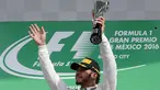 Pembalap tim Mercedes, Lewis Hamilton mengangkat trofi , setelah menjuarai balapan F1, di Grand Prix Meksiko yang berlangsung di Sirkuit Autodromo Hermanos Rodriguez, Mexico City, Meksiko (30/10). (Reuters/Henry Romero)