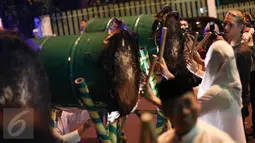 Seorang turis bersama pengguna jalan lainnya mencoba memukul bedug saat malam takbiran di depan Kantor DPP PPP, Jakarta, Selasa (5/7). Pemerintah melalui Kemenag telah menetapkan 1 Syawal 1437 H jatuh pada tanggal 6 Juli 2016. (Liputan6.com/Faizal Fanani)