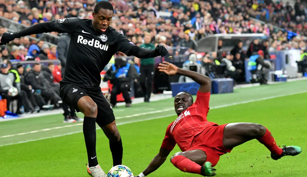 Pemain Red Bull Salzburg Enock Mwepu (kiri) berebut bola dengan pemain Liverpool Sadio Mane saat pertandingan Grup E Liga Champions di Salzburg, Austria, Selasa (10/12/2019). Liverpool menang 2-0 dan lolos ke babak 16 besar Liga Champions. (AFP/Kerstin Joensson)