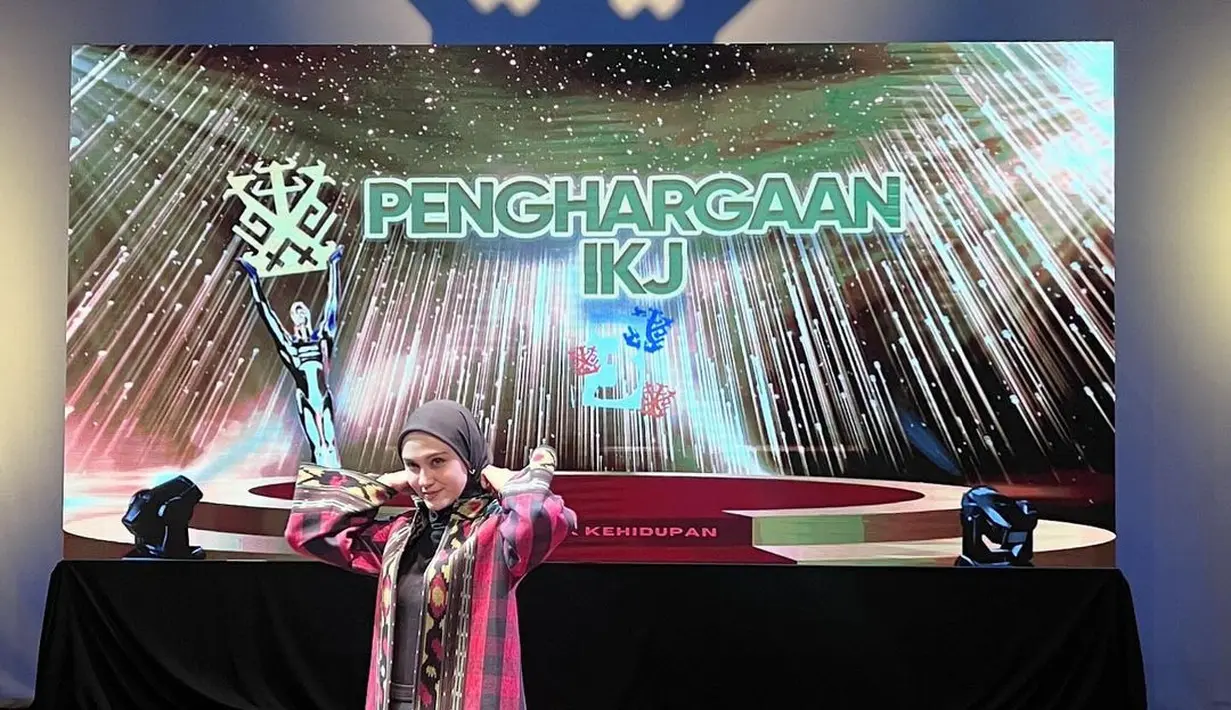 Kerennya Zee Zee Shahab memadukan outfitnya yang serba hitam dengan outer panjang dari kain tenun bernuansa merah. [Foto: Instagram/zeezeeshahab]