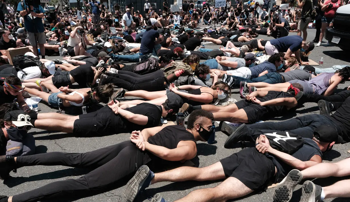 Anggota komunitas LGBTQ bersama pengunjuk rasa Black Lives Matter melakukan aksi tiarap di jalan dengan tangan seolah terikat di West Hollywood, California, Rabu (3/6/2020). Aksi menyimbolkan momen terakhir George Floyd saat lehernya ditindih lutut polisi Minneapolis pada 25 Mei. (AP/Richard Vogel)