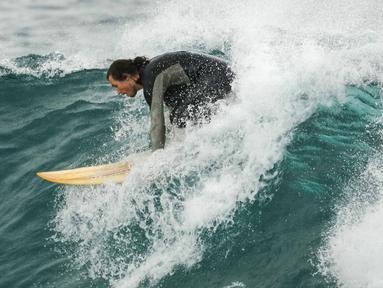 Seorang peselancar berselancar di Pantai Bronte, Sydney, Australia, 24 Mei 2022. (AP Photo/Mark Baker)