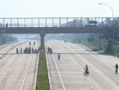 Warga berolahraga di proyek Jalan Tol Cijago Seksi II, kawasan Kukusan, Depok, Minggu (6/1). Proyek yang hampir rampung itu dimanfaatkan untuk berolahraga dengan menyusuri jalur yang belum dilalui kendaraan bermotor. (Liputan6.com/Immanuel Antonius)