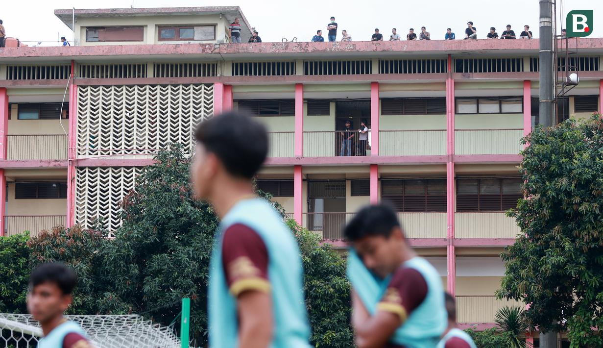 Penonton menyaksikan pertandingan antara Arema FC melawan PSM Makassar dari atap asrama Kepolisan pada laga BRI Liga 1 di Stadion PTIK, Jakarta, Sabtu (4/2/2023). Pertandingan tersebut sebenarnya digelar tanpa penonton. (Bola.com/M Iqbal Ichsan)