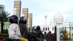 Pengendara motor antre mengambil takjil yang dibagikan dengan sistem drive thru di Masjid Agung Al-Azhar, Jakarta, Selasa (5/5/2020). Selama Ramadan, pengurus Masjid Agung Al-Azhar membagikan 300 takjil per hari buat pengendara yang melintasi lokasi tersebut. (Liputan6.com/Helmi Fithriansyah)