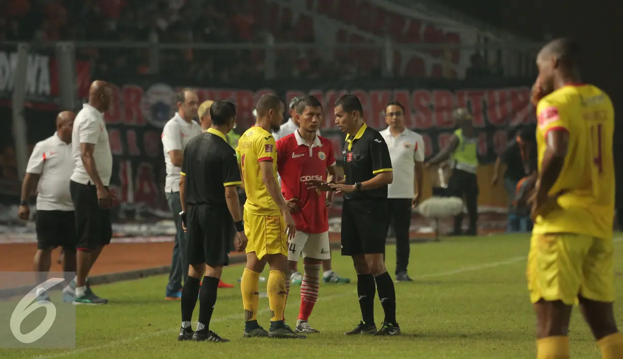 Wasit Djumadi E berbincang dengan kapten Persija dan Sriwijaya FC saat penghentian laga Torabika Soccer Championship presented by IM3 Ooredoo di Stadion GBK Jakarta, Jumat (24/6). Saatdihentikan, Sriwijaya FC unggul 1-0. (Liputan6.com/Helmi Fithriansyah)
