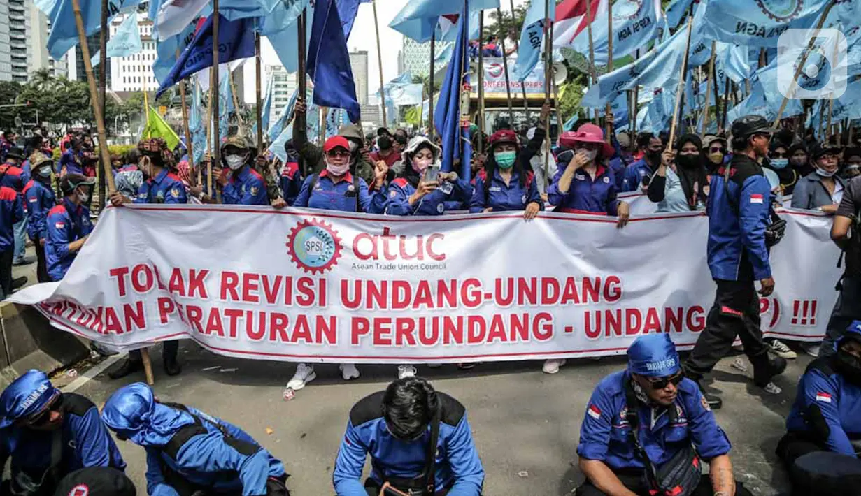 Massa buruh yang tergabung dalam Konfederasi Serikat Pekerja Seluruh Indonesia (KSPSI) dan Serikat Pekerja Nasional (SPN) demo di kawasan Patung Kuda, Jakarta, Kamis (12/5/2022). Aksi tersebut untuk memperingati May Day serta menolak Omnibuslaw UU Cipta Kerja Nomor 11 Tahun 2020 dan meminta klaster ketenagakerjaan kembali ke substansi UU Nomor 13 Tahun 2003. (Liputan6.com/Faizal Fanani)