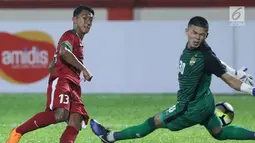 Pemain sayap Timnas Indonesia U-23, Febri Hariyadi mencoba mengecoh kiper Thailand U-23 saat uji coba di Stadion PTIK, Jakarta, Kamis (31/5). Babak pertama, Indonesia U-23 ditahan imbang Thailaind U-23. (Liputan6.com/Helmi Fithriansyah)