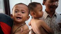 Anak balita menangis saat ditimbang di Puskesmas, Kaduhejo, Pandeglang (14/9). Dengan puluhan penduduk mengalami gizi kurang, gizi buruk dan beberapa anak sudah divonis stunting, ini menjadi gambaran bagaimana sulitnya mencegah stunting. (Foto:Istimewa)