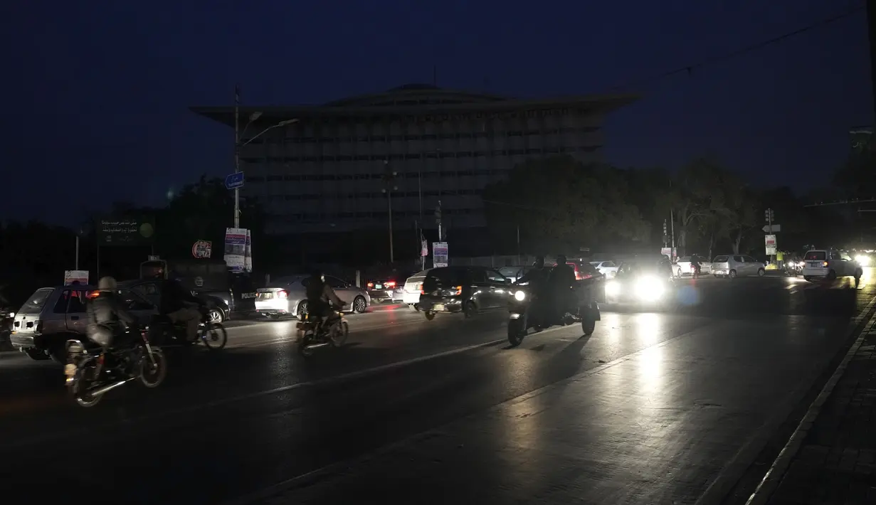 Pengendara sepeda motor dan mobil berkendara di jalan selama pemadaman listrik nasional, di Lahore, Pakistan, Senin, 23 Januari 2023. Lampu-lampu lalu lintas dan layar komputer tampak gelap di Pakistan pada Senin (23/1) setelah pemadaman listrik di seluruh penjuru negara itu karena gangguan besar pada jaringan listrik nasionalnya. (AP Photo/K.M. Chaudary)