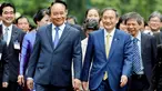 PM Jepang, Yoshihide Suga (kanan tengah) berjalan bersama dengan PM Vietnam, Nguyen Xuan Phuc (kiri depan) setibanya di Istana Kepresidenan, di Hanoi, Vietnam, Senin (19/10/2020). Yoshihide Suga melakukan kunjungan resmi ke Vietnam hingga 20 Oktober 2020.  (AP Photo/Minh Hoang, Pool)