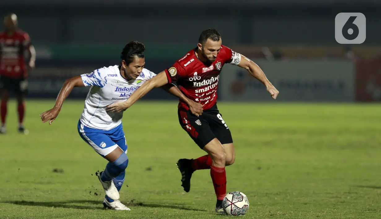Pemain Bali United Ilija Spasojevic berebut bola dengan pemain Persib Bandung Achmad Jufriyanto pada laga BRI Liga 1 di Stadion Indomilk Arena, Tangerang, Sabtu (18/9/2021). Persib Bandung ditahan imbang 10 pemain Bali United dengan skor 2-2. (Bola.com/M. Iqbal Ichsan)
