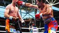 Manny Pacquiao (kanan) melepas pukulan ke Jeff Horn pada perebutan gelar WBO kelas Welter di Suncorp Stadium, Brisbane, Australia, Minggu (2/7/2017). Pacquiao kalah angka telak. (AFP/Patrick Hamilton)