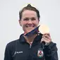 Atlet Flora Duffy dari Bermuda berpose dengan medali emasnya di podium setelah memenangkan kompetisi triathlon individu putri Olimpiade Tokyo 2020 di Odaiba Marine Park, Tokyo, Jepang, Selasa, 27 Juli 2021. (Loic VENANCE / AFP)