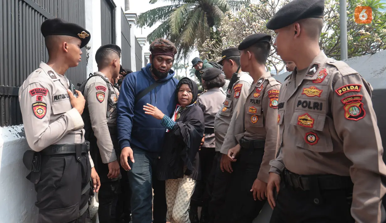 Petugas kepolisian mengeluarkan seorang pendemo wanita yang berusaha masuk ke dalam gedung DPR saat aksi Aliansi Masyarakat Pati Bersatu (AMPB) di Jakarta, Kamis (27/8/2026). (KLY/Budy Santoso)