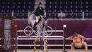 Cian O'Connor dari Irlandia mengendarai Kilkenny melewati patung pegulat sumo kecil di kualifikasi individu lompat berkuda selama Olimpiade Tokyo 2020 di Equestrian Park di Tokyo(3/8/2021). (AFP/Behrouz Mehri)