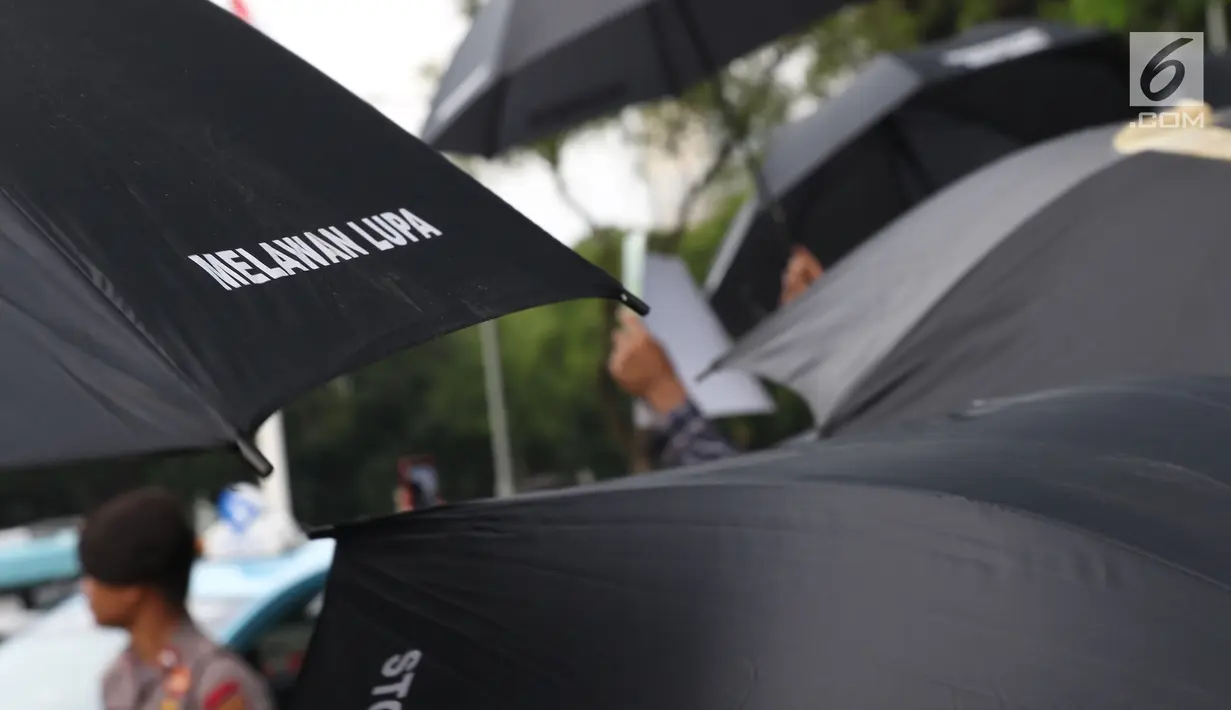 Aktivis saat aksi Kamisan di depan Istana Merdeka, Jakarta, Kamis (13/12). Mereka meminta pemerintah segera menyelesaikan kasus-kasus pelanggaran HAM di Indonesia. (Liputan6.com/Helmi Fithriansyah)