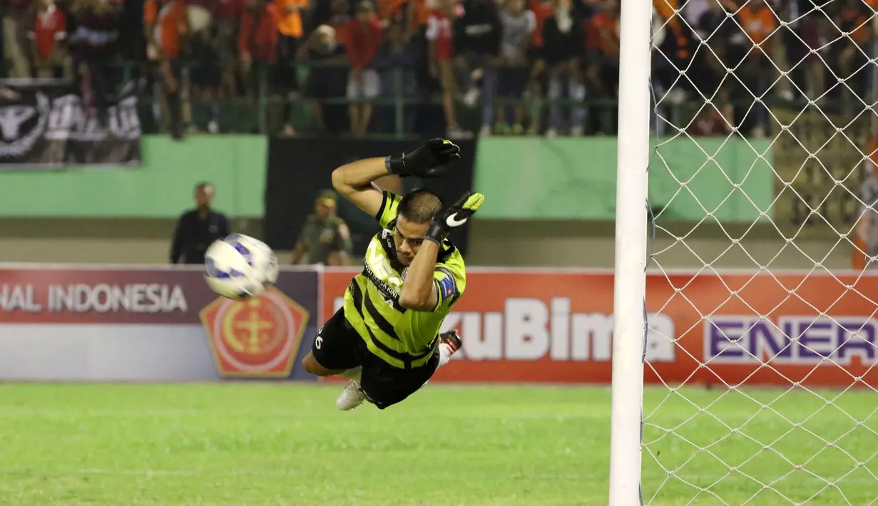 Kiper Persija, Andritany terbang menghalau bola pada laga Piala Jenderal Sudirman di Stadion Manahan, Solo, Selasa (15/12/2015). (Bola.com/Nicklas Hanoatubun)