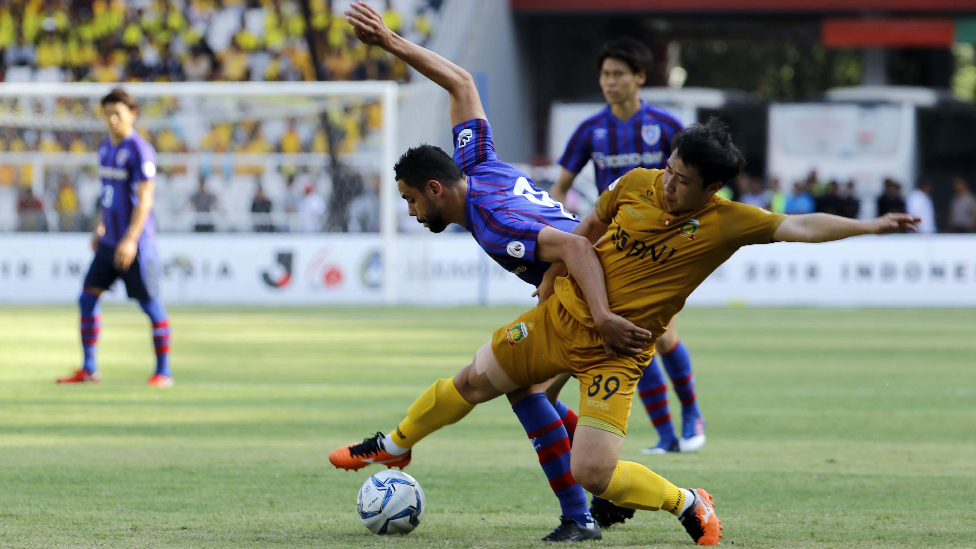 Duel Diego Oliveira (kiri) striker FC Tokyo, dengan Lee Yoo Jun asal Bhayangkara FC dalam laga persahabatan di Stadion Utama Gelora Bung Karno, Senayan Jakarta pada Sabtu (27/1/2018). (Bola.com/Peksi Cahyo)