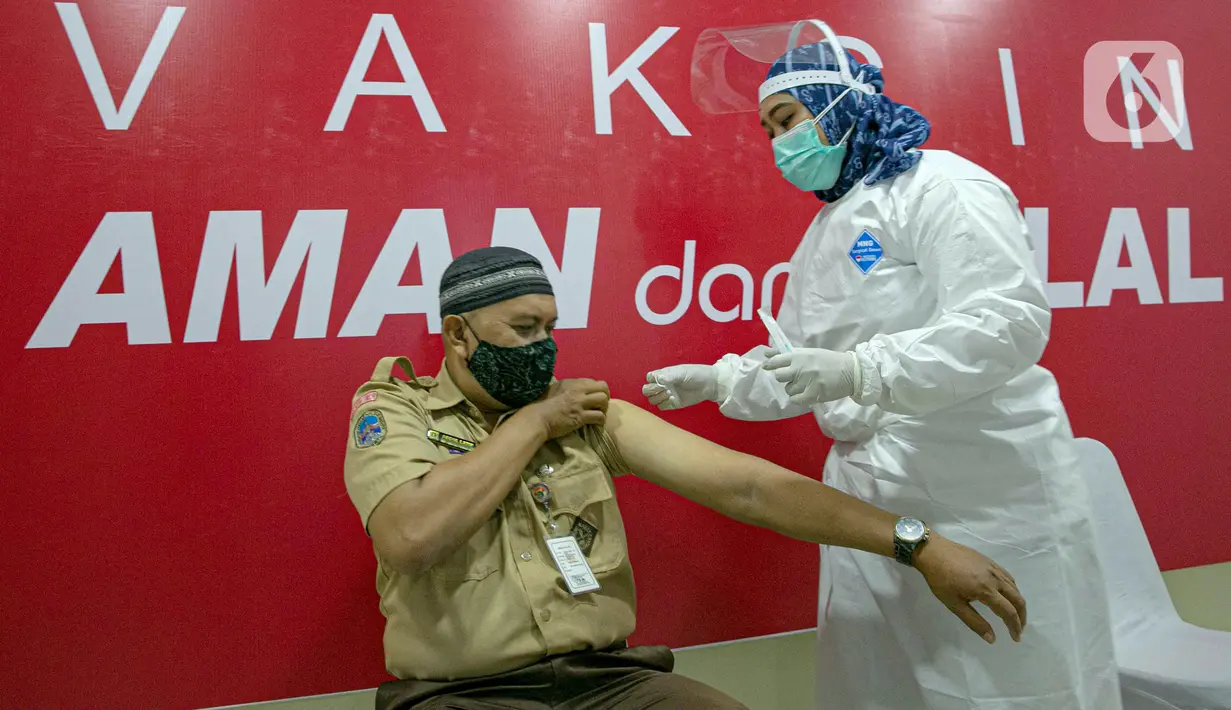Vaksinator menyuntikkan vaksin COVID-19 kepada guru di SMA 70, Jakarta, Rabu (25/2/2021). Sebanyak 600 orang dari profesi guru, tenaga kependidikan, dan dosen akan divaksin COVID-19 hari ini. (Liputan6.com/Faizal Fanani)