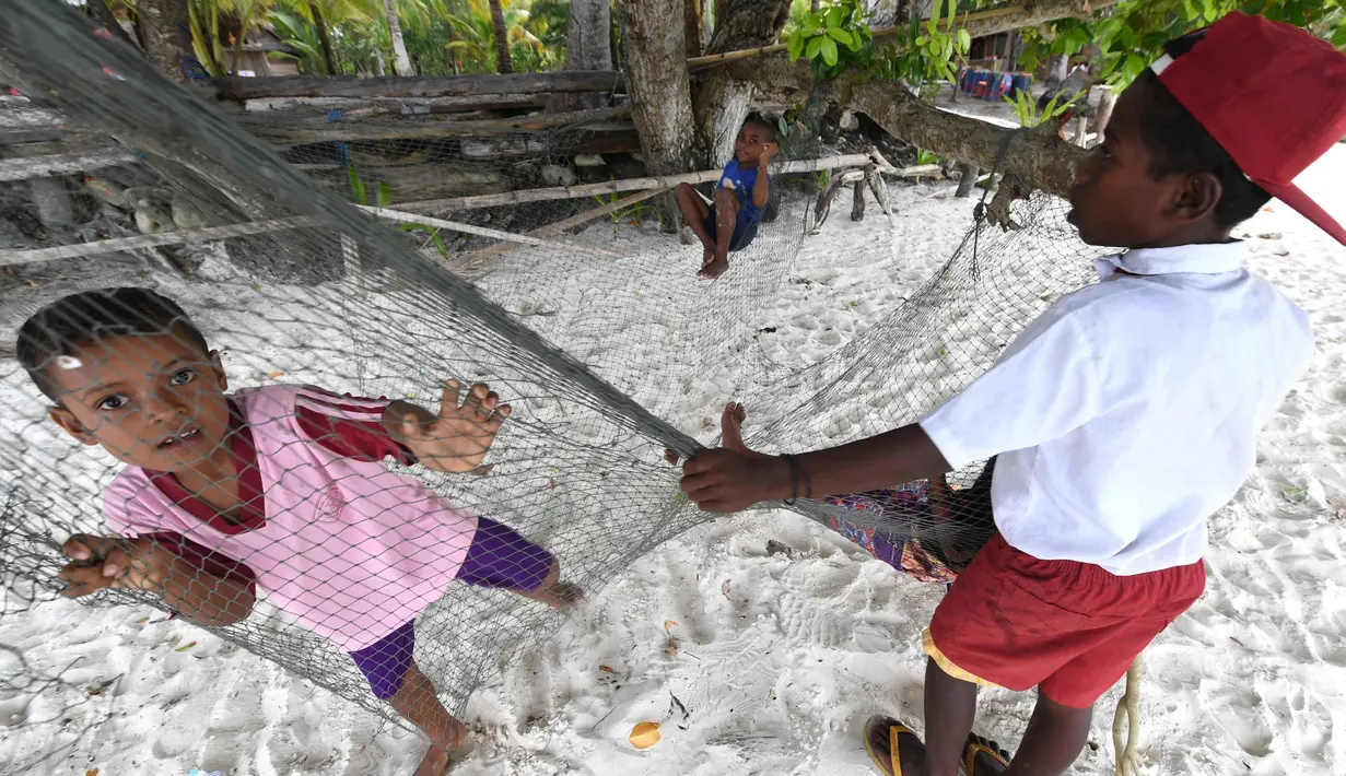 Anak-anak suku Byak Betew bermain di tepi pantai di pulau Saukabu, satu dari 1.500 pulau di Raja Ampat 20 Agustus 2017. Raja Ampat merupakan rumah bagi sekitar 1.400 jenis ikan dan 600 spesies karang. (AFP Photo/Goh Chai Hin)