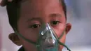 Seorang anak yang mengalami cedera akibat gempa Lombok menerima asupan oksigen di sebuah rumah sakit darurat di Tanjung, Selasa (7/8). Lebih dari 70.000 orang kehilangan tempat tinggal akibat gempa Lombok berkekuatan 7 SR. (AP/Tatan Syuflana)