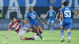 Pemain Persib Bandung, David Da Silva (kanan) berebut bola dengan pemain Madura United, Jacob Mahler pada laga leg 1 final Championship Series BRI Liga 1 2023/2024 antara Persib Bandung melawan Madura United di Stadion Si Jalak Harupat, Bandung, Minggu (26/05/2024). (Bola.com/M Iqbal Ichsan)