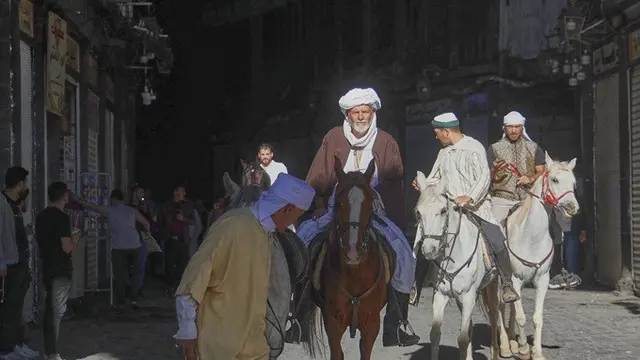 Jemaah haji, termasuk tiga orang dari Spanyol, berpose dengan kuda mereka di luar Pasar al-Hamidiyah di Damaskus, Suriah, 21 April 2025, selama perjalanan berkuda selama berbulan-bulan dari Spanyol ke Arab Saudi untuk melaksanakan ibadah haji.