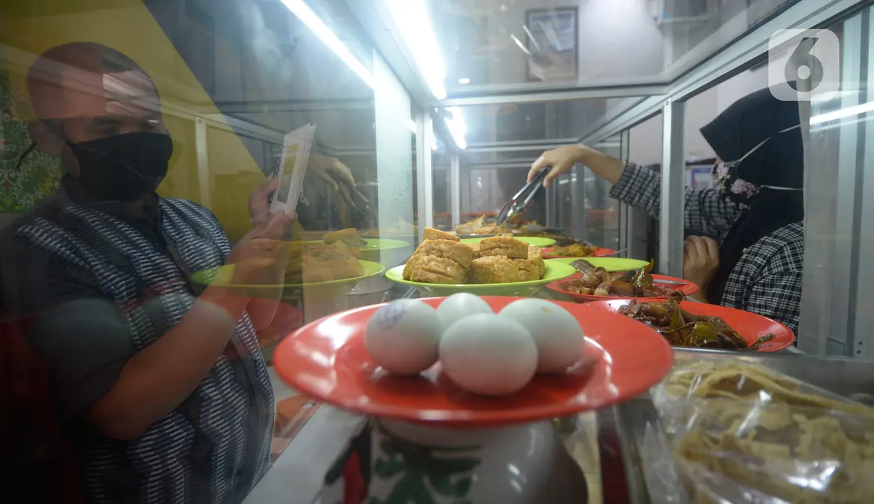 Pengunjung tuna netra memilih menu makanan menggunakan panduan buku braille di Warteg FAST, Graha Raya Bintaro, Tangerang Selatan, Banten, Kamis (3/12/2020). (merdeka.com/Dwi Narwoko)