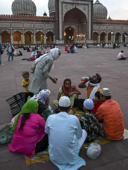 Umat Muslim berbuka puasa di masjid Jama Masjid pada hari pertama bulan suci Ramadhan, di New Delhi (14/4/2021). Masjid ini didirikan oleh Kaisar Mogul, Syah Jehan, yang juga membangun Taj Mahal. (AFP/Prakash Singh)