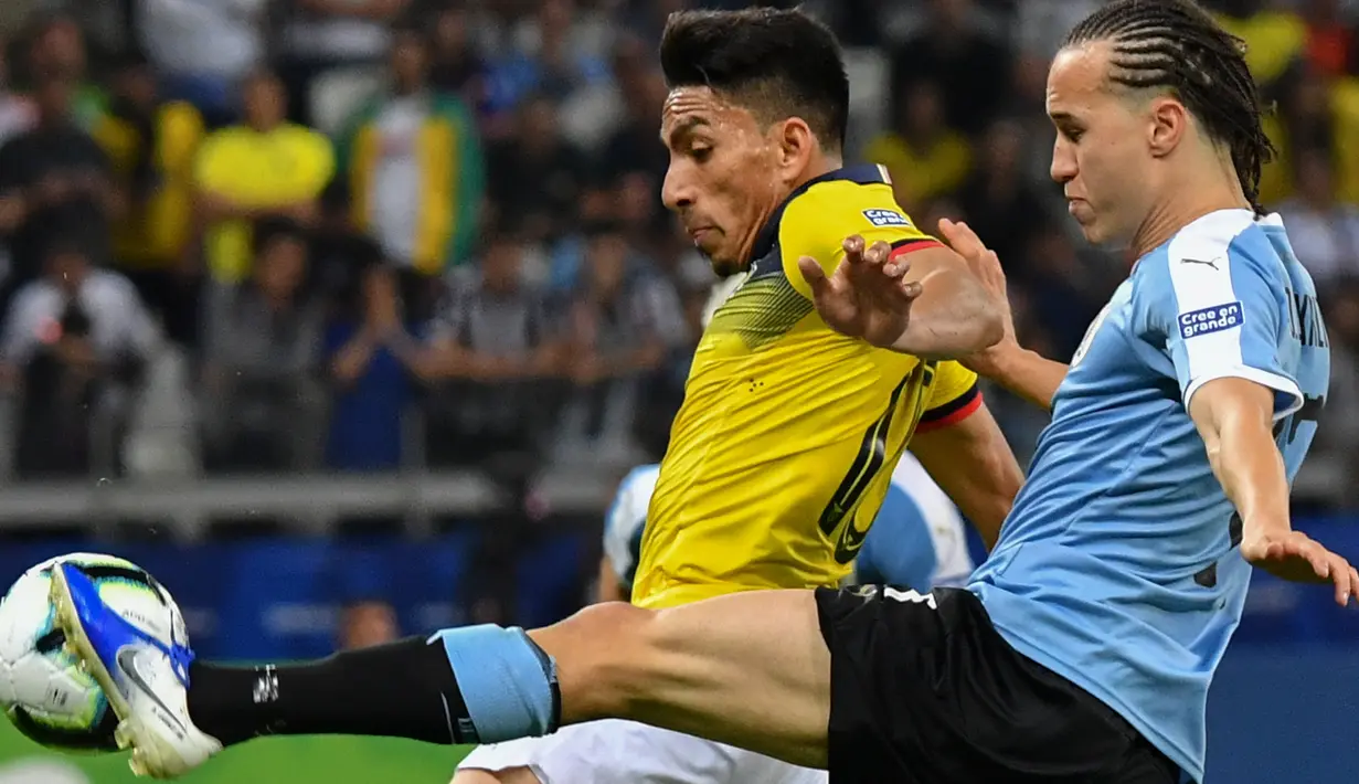 Pemain timnas Ekuador, Angel Mena berebut bola dengan pemain timnas Uruguay, Diego Laxalt dalam laga pertama Grup C Copa America 2019 di Stadion Mineirao, Brasil, Minggu (16/6/2019). Uruguay berhasil memetik kemenangan besar 4-0 atas Ekuador. (Luis ACOSTA / AFP)