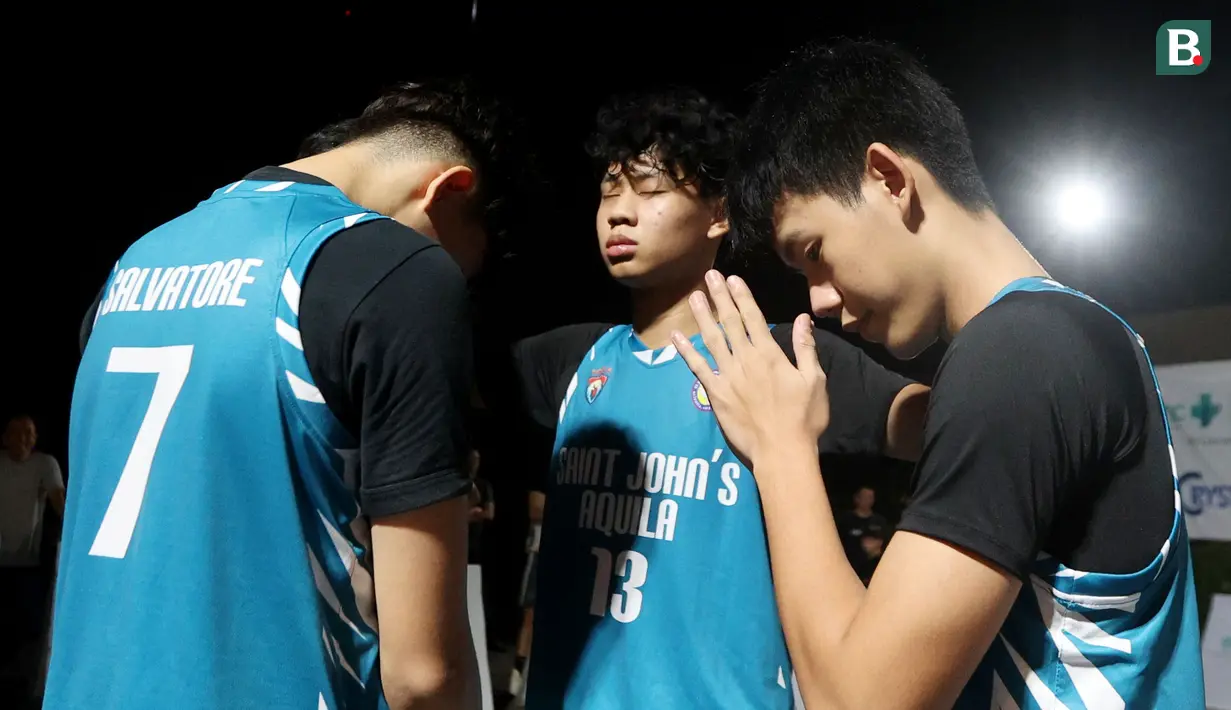 Pebasket SMA Saint John Aquila berdoa sebelum bertanding pada laga kompetisi basket 3x3 di Pacific Garden, Tangerang, Minggu (28/4/2024). (Bola.com/M Iqbal Ichsan)