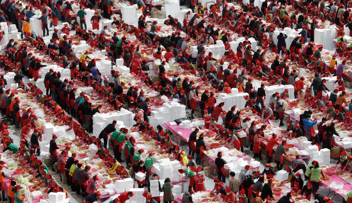 Peserta membuat kimchi, hidangan tradisional Korea Selatan, selama Festival Kimchi tahunan di pusat kota Seoul, Jumat (3/11). Sekitar 4.700 peserta diharapkan mampu menghasilkan 120 ton kimchi. (AP Photo/Ahn Young-joon)