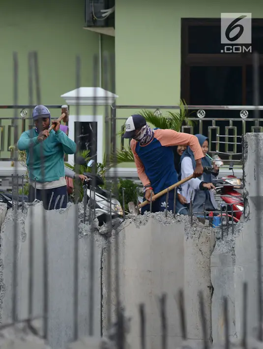 Pekerja membongar bangunan saat memasang turap di Kali Item, Jakarta, Rabu (2/1). Turap sepanjang 1.900 meter pada sisi kanan dan kiri kali untuk mengantisipasi genangan dan banjir di kawasan tersebut pada musim hujan. (Merdeka.com/Imam Buhori)